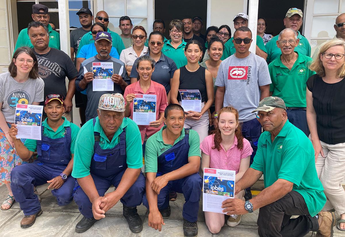 Invasive non-native species workshop participants on St Helena hold copies of the IPBES biological invasions on islands factsheet