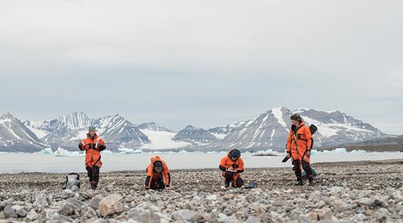 Four scientists taking measurements on Svalbard