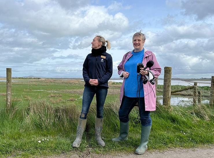 Two people standing at the edge of a saltmarsh