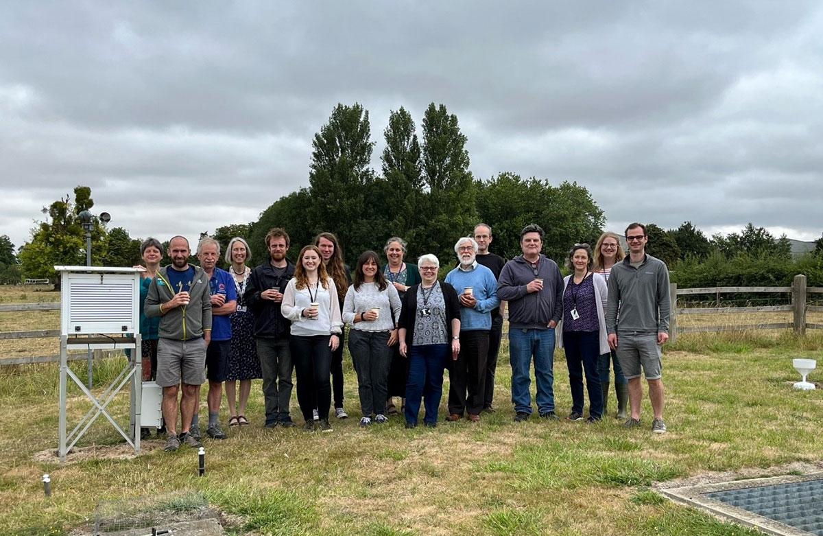 Group of people outside beside meteorological monitoring equipment