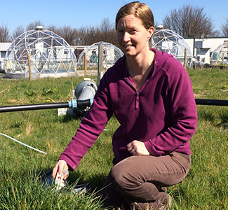 Felicity at work in the CEH solardomes Woman kneeling on grass