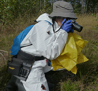 Jacky on location in the Red Forest Woman in hazard suit taking a photo