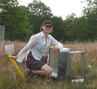 Sabine on site at a field manipulation experiment Woman kneeling in a field