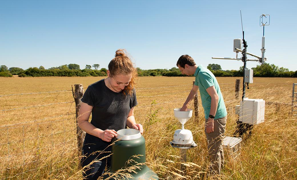 Two UKCEH scientists working at a COSMOS soil moisture monitoring station