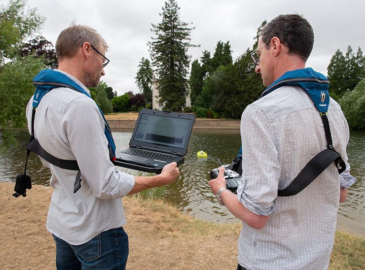Mike Bowes and Nick Everard looking at results from the remote-controlled ArcBoat on the river Thames