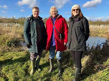 Sue Nelson, Ann Berkeley and Alice Hope beside a pond on the Bruern estate