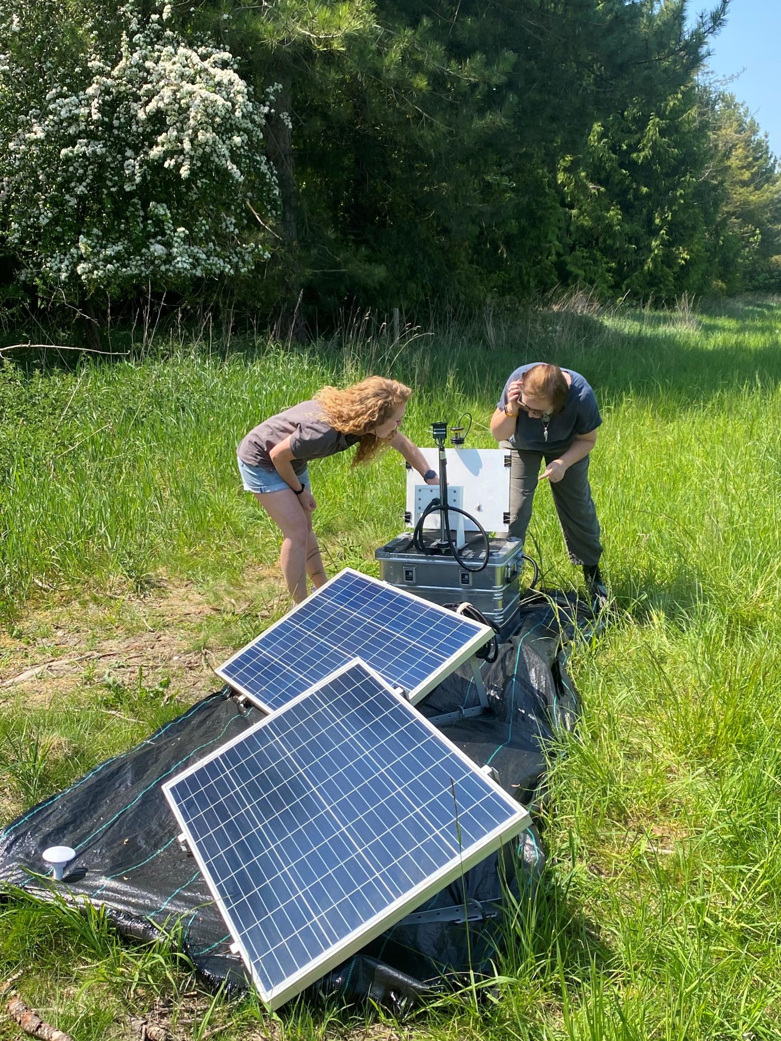 Two people looking at instrumentation in the field