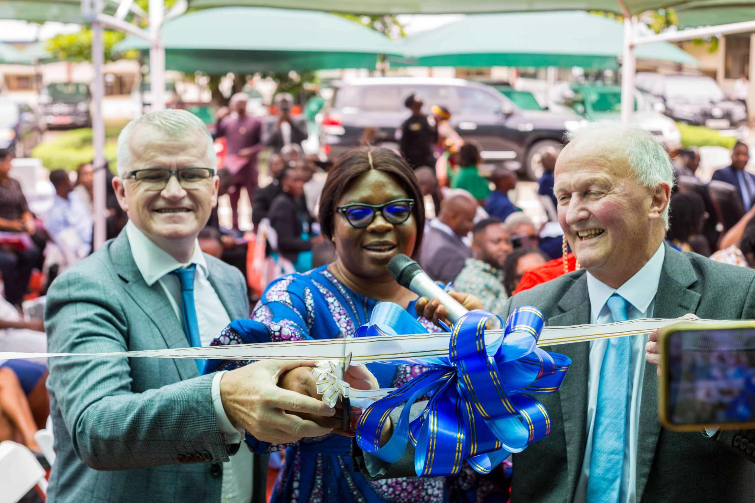 Three people cutting the ribbon