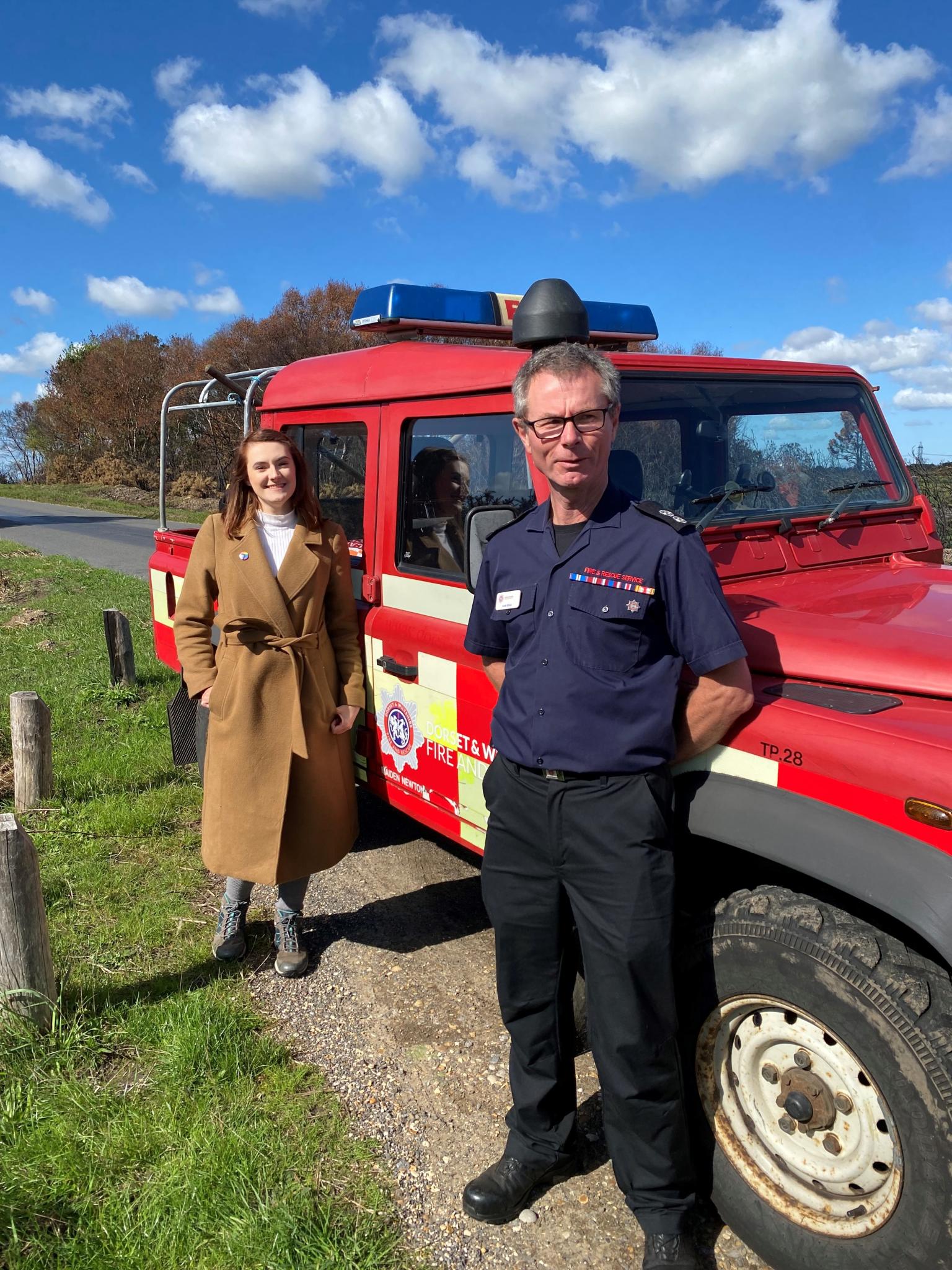 Two people in front of a fire vehicle