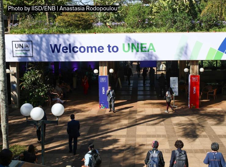 People approach entrance to building under a banner saying Welcome to UNEA