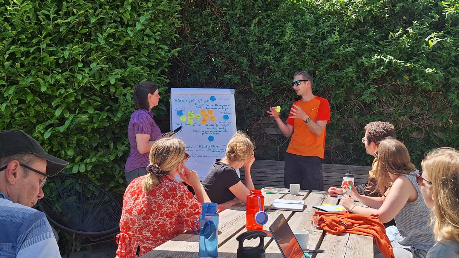 Researchers with a flipchart and others seated nearby