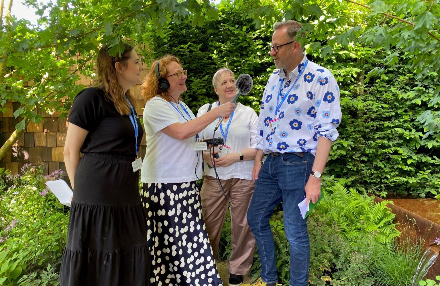 4 people talking in a garden