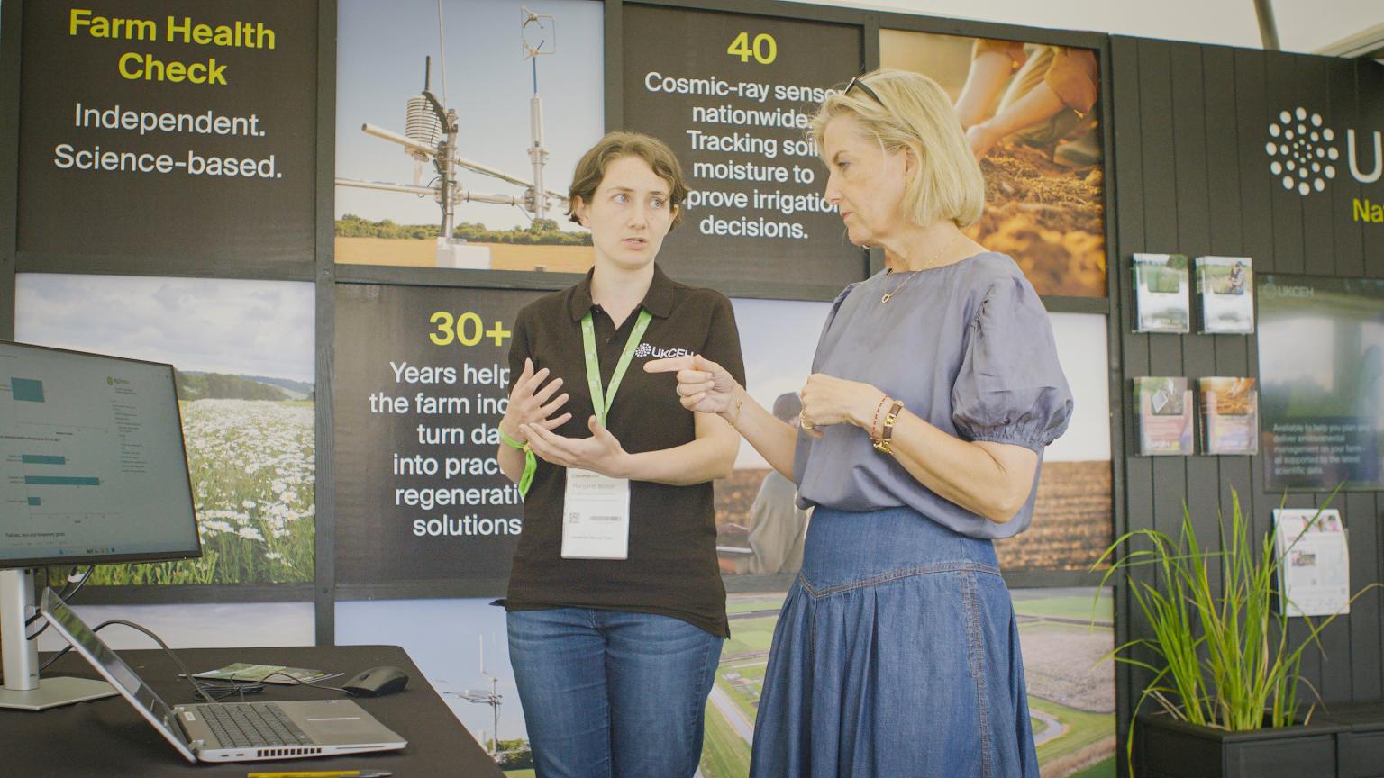 Two people talking in front of a display