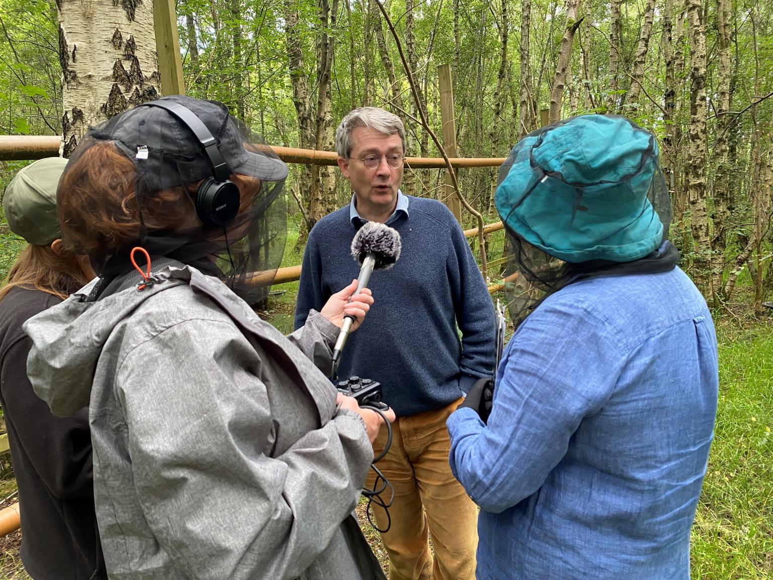 Man being interviewed in a woodland