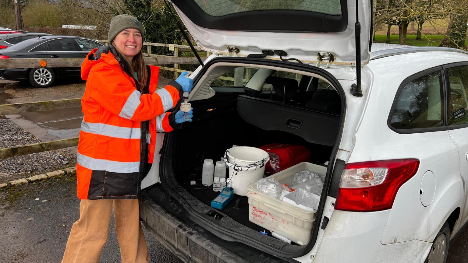 Woman at the back of a car with equipment