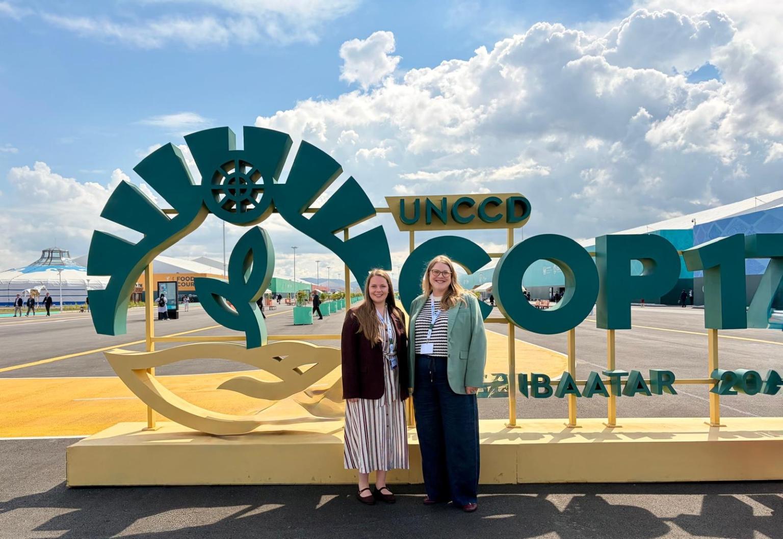 Two women in front of COP17 sign