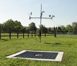 Ground level raingauge in the foreground and Automatic Weather Station in the background