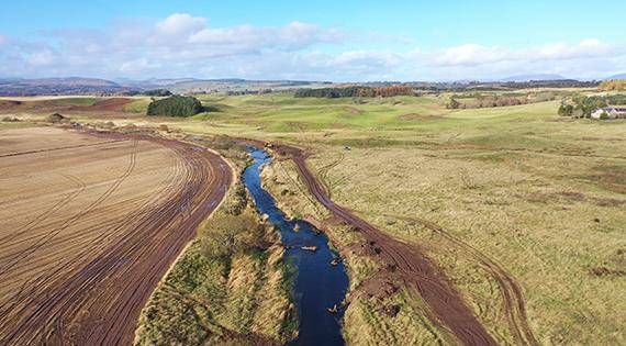 Aerial view over small river and surrounding floodplain