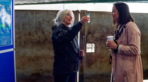 Person showing water sample to another person