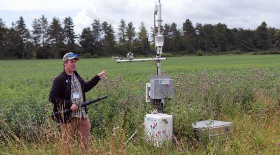 Ross Morrison from UKCEH beside a flux tower that measures site-level greenhouse gas emissions 