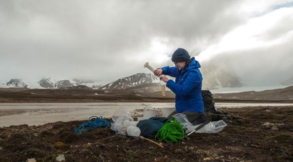 UKCEH scientist Alex O'Brien setting up algae dialysis bag on fieldwork in Svalbard