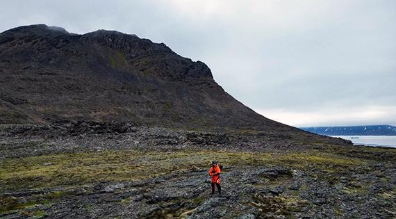 Lone person standing on a rocky Arctic surface