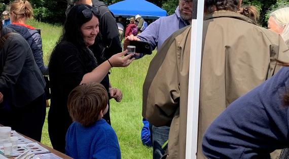 Person uses a mobile phone to photograph a container held by another person