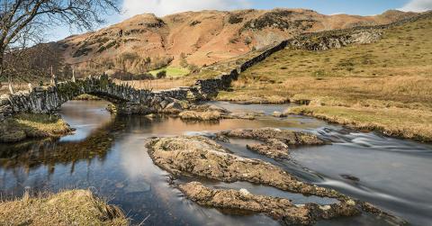 Little Langdale in the Lake District River and bridge beside hill