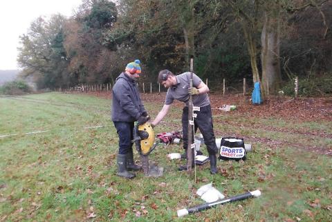 Two scientists extracting soil from a field