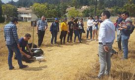 Testing the drone at high altitude within the UPTC grounds Group of people looking at a small drone