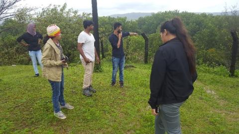 Four people standing outside in a field in India