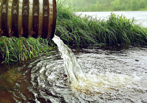 Water flowing rom a pipe into a river