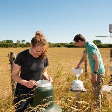 Two UKCEH scientists working at a COSMOS soil moisture monitoring station