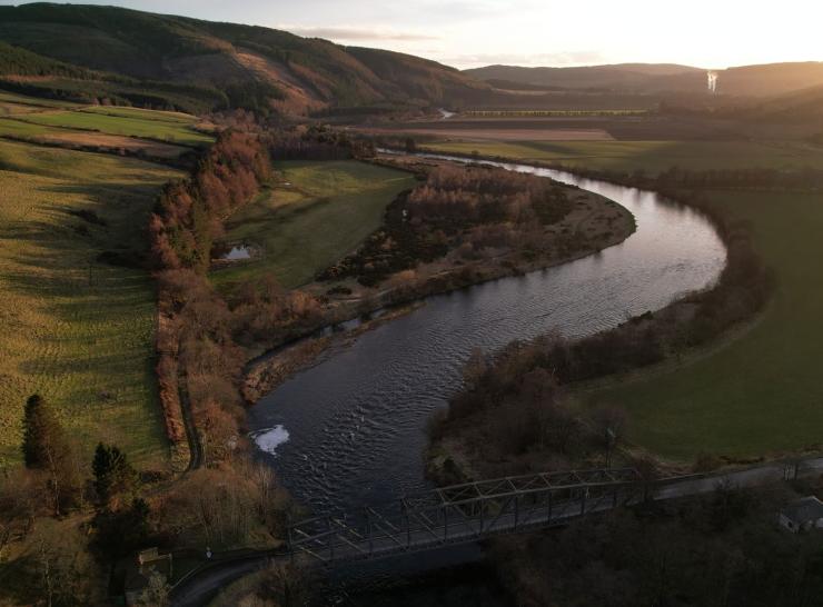 Drone view of river snaking between green fields