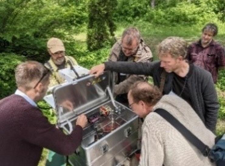 People looking inside a metal box