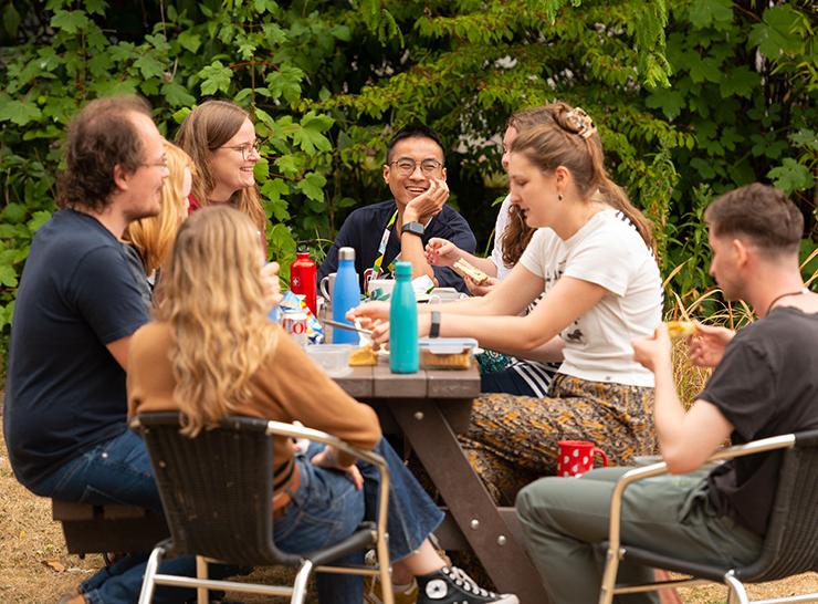 Group of UKCEH people sitting outside at a picnic table at our Wallingford site