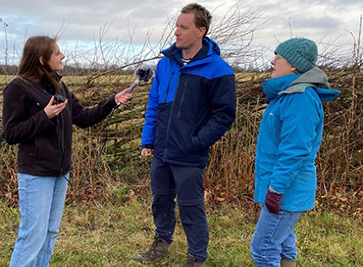 Three UKCEH people recording a podcast beside a hedgerow