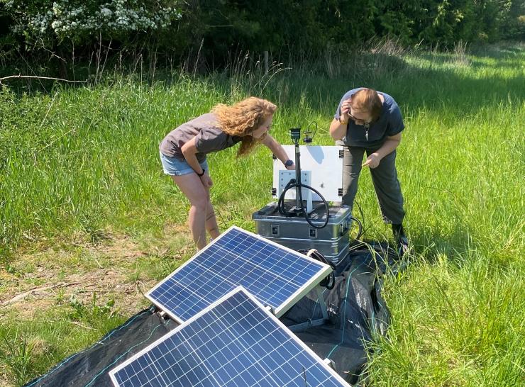 Two people looking at instrumentation in the field