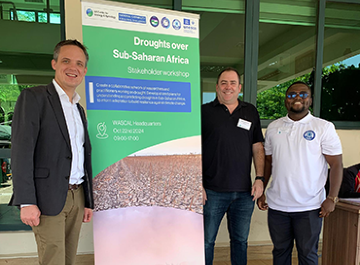 Three people stand beside a banner called Droughts over Sub-Saharan Africa
