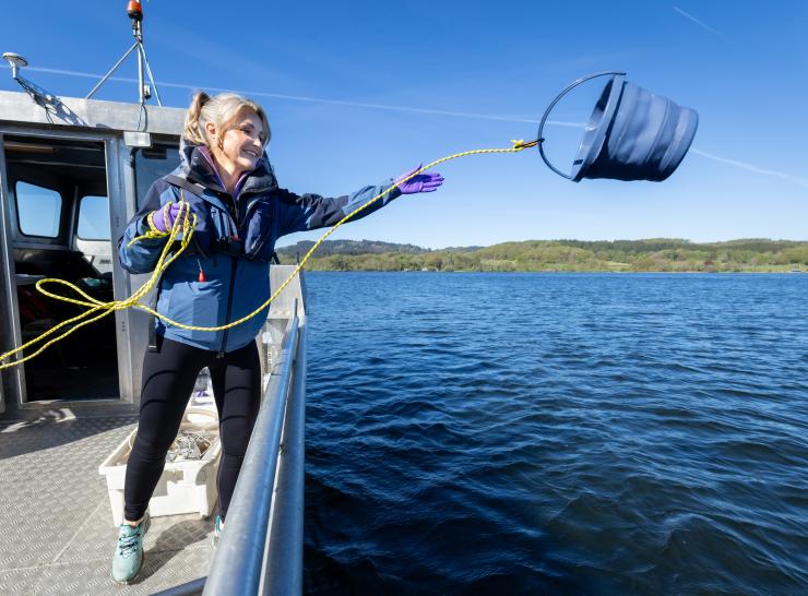 Woman on a boat throwing a bucket on a rope