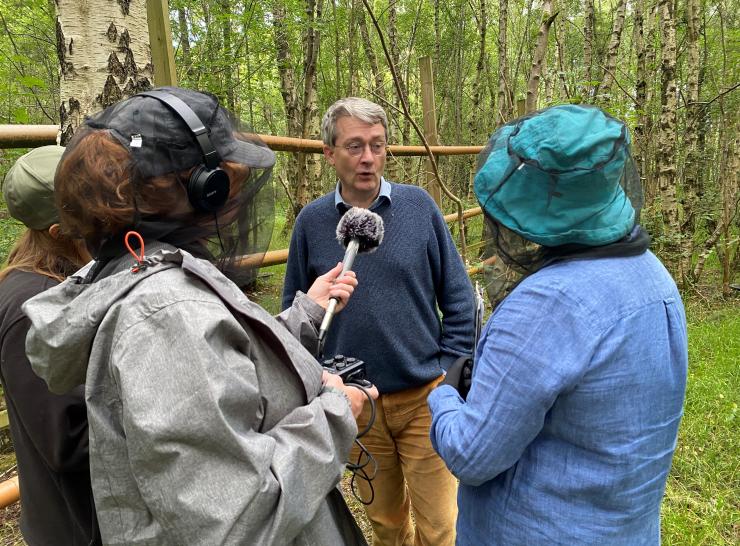 Man being interviewed in a woodland