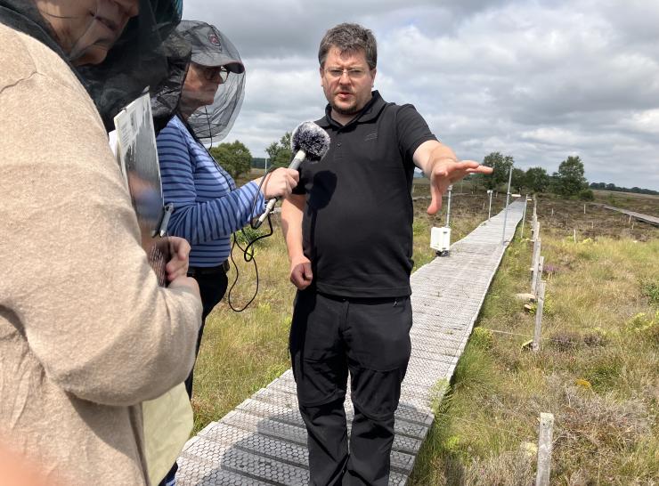 Man talking into microphone at peatland site