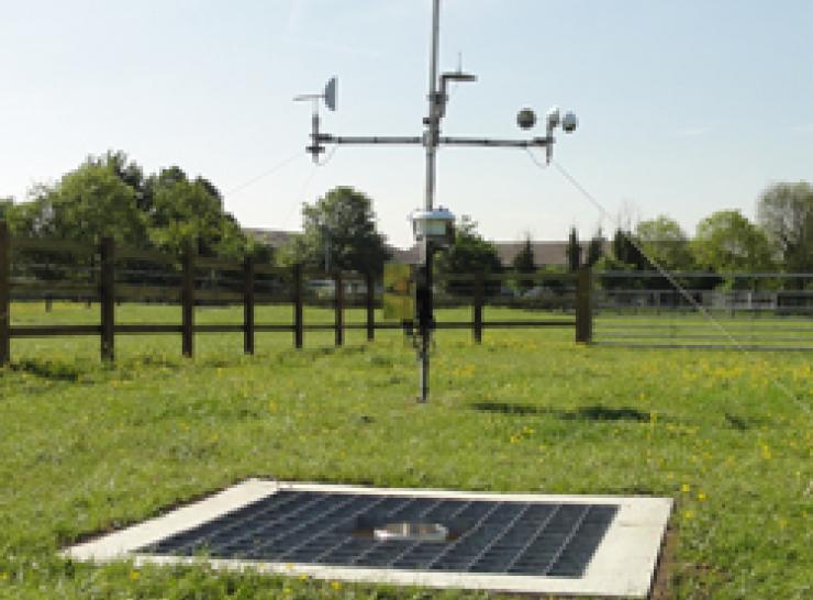 Ground level raingauge in the foreground and Automatic Weather Station in the background