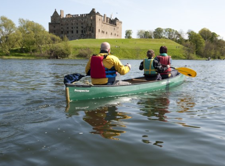 3 people paddling in a small boat on Linlithgow Loch