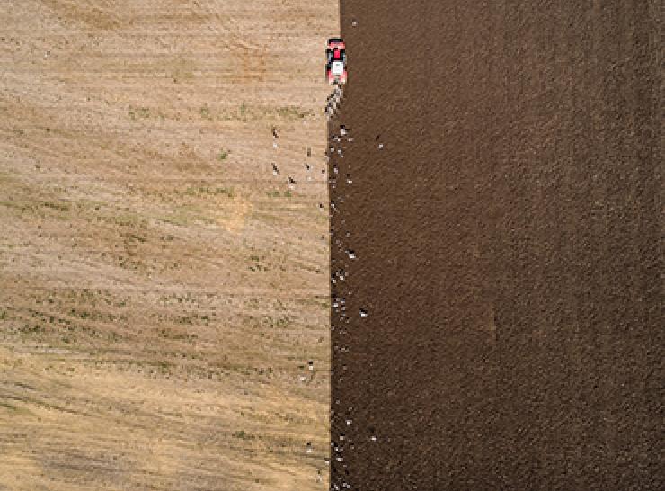 Aerial shot of a tractor ploughing a field